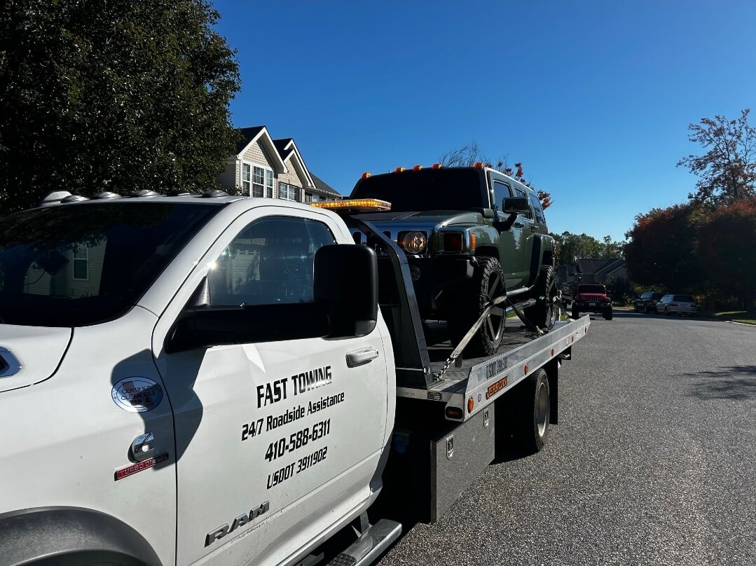 Flatbed tow truck loading a jeep