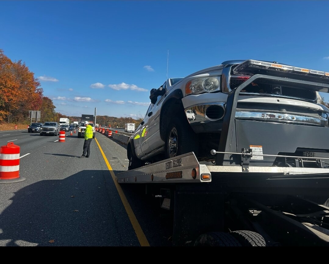 Flatbed tow truck transporting a vehicle